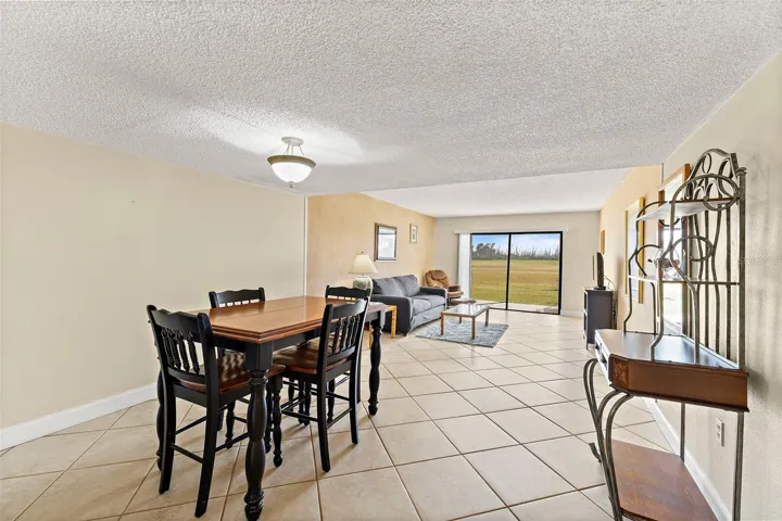 Spacious living and dining area with tile flooring, sliding glass door to patio