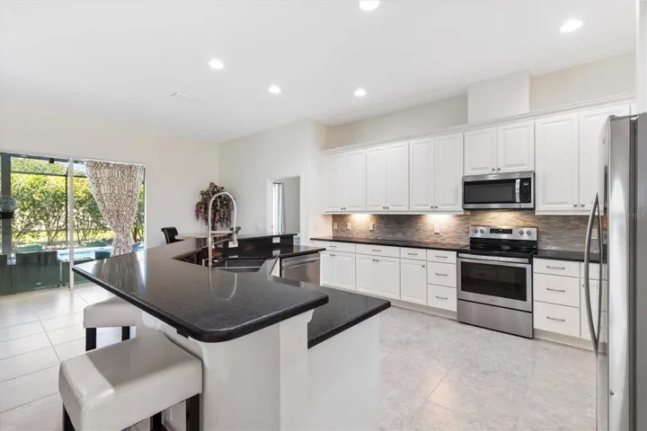 Kitchen with Quartz counter tops, backsplash, stainless steel appliances, hood vented to outside, softclose drawers.