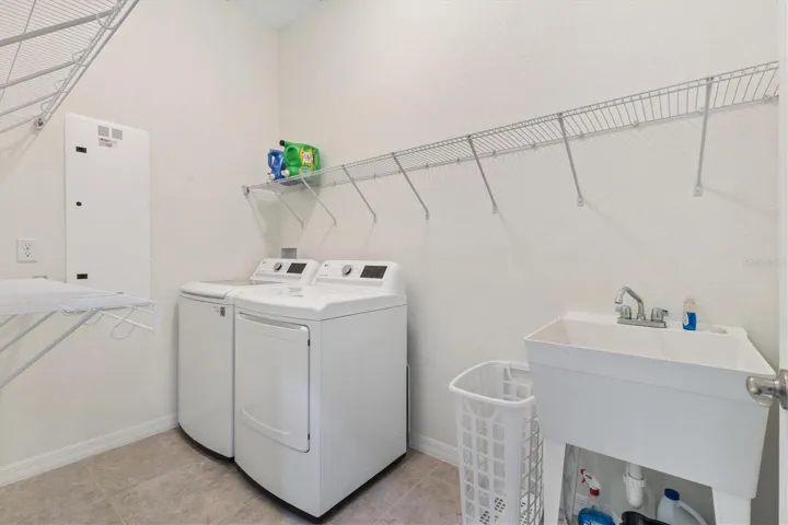 Inside laundry room with shelving and laundry tub.