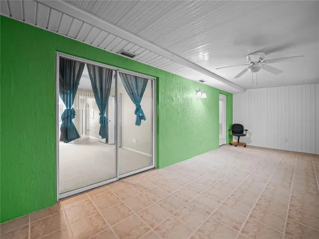 Enclosed rear patio with sliding doors into primary bedroom.