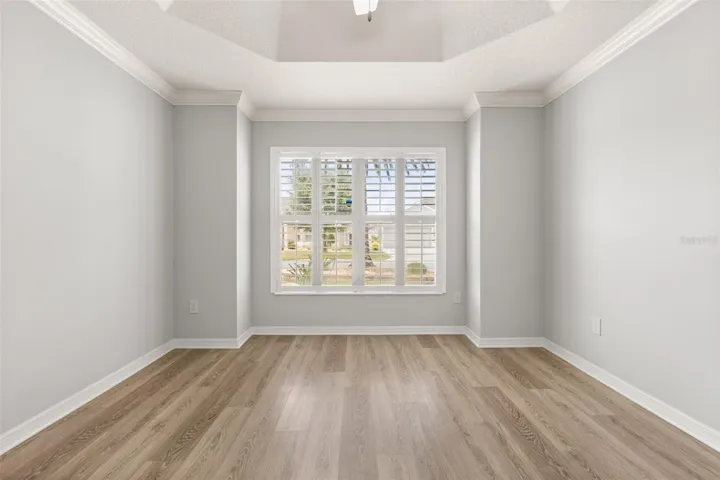 Front guest bedroom with tray ceiling and plantation shutters.