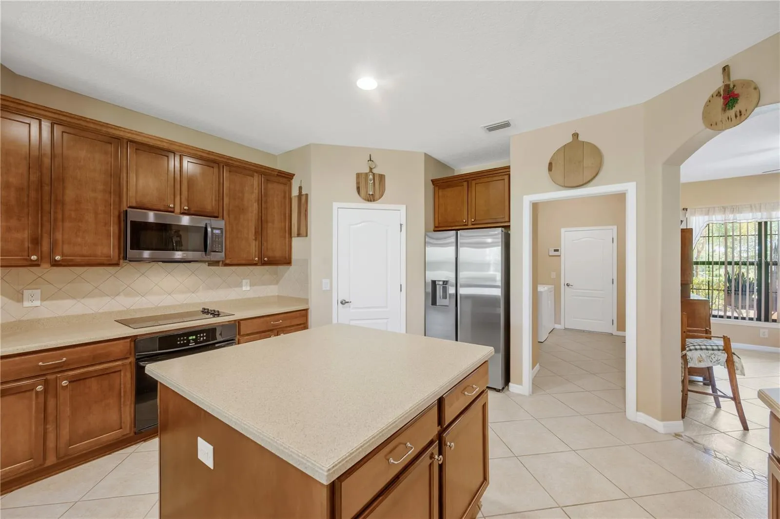 The large kitchen island is a true workhorse, offering abundant prep space, storage, and functionality for everyday living and entertaining.