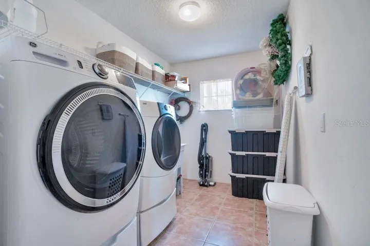 A generous upstairs Laundry Room with UTILITY SINK and storage shelving adds everyday convenience.