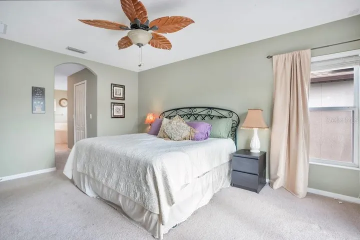 Upstairs, the Primary Suite feels like a private escape, featuring a stylish ceiling fan, DUAL WALK-IN CLOSETS, and PRIVATE BALCONY ACCESS through sliding doors, where you can unwind while taking in peaceful water views.