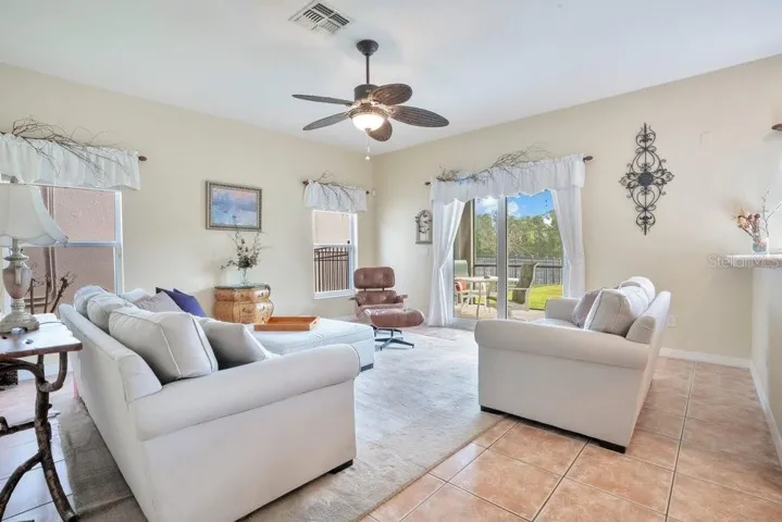 Overlooking it all, the Family Room is both open and inviting, complete with ceramic tile flooring and NEW IMPACT, ENERGY-EFFICIENT SLIDING GLASS DOORS that lead to the outdoor living space.