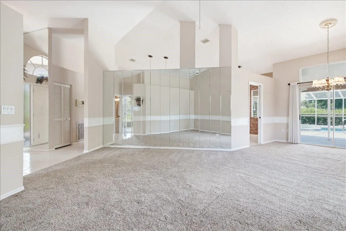 Open main living and dining rooms with openings into kitchen and den