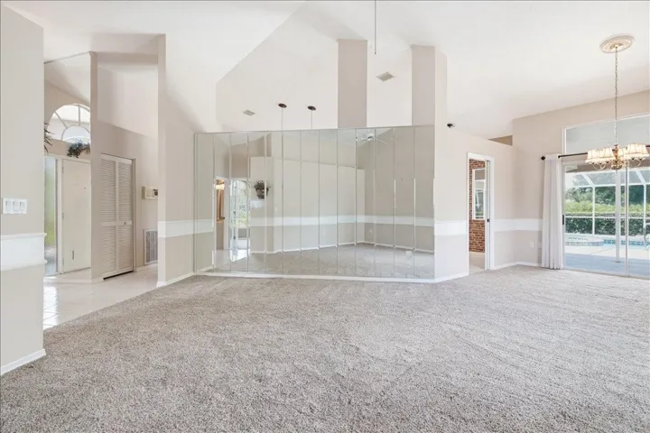 Open main living and dining rooms with openings into kitchen and den