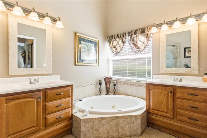 Primary bath features whirlpool garden tub and split vanities