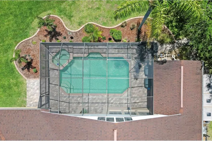 A nice aerial view of the pool, jacuzzi, and rear landscaping.