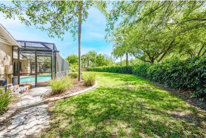 The yard backs up to a concrete wall covered with green foliage.