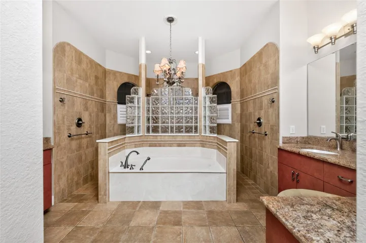 Primary bath has a separate garden tub and "car wash" shower.