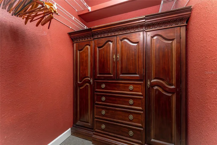 Another large walk in closet with built in storage etagere.