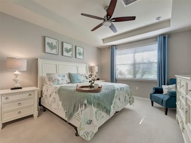 Primary Bedroom with custom paint, ceiling fan and new carpet.