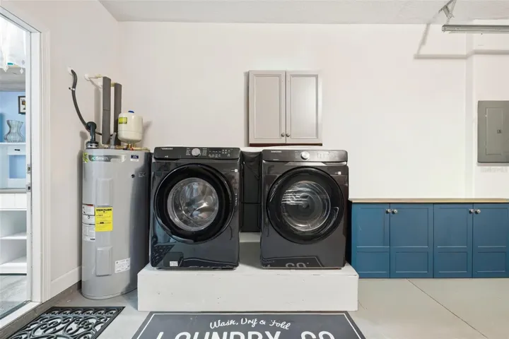 Laundry area just inside the garage with ample storage.