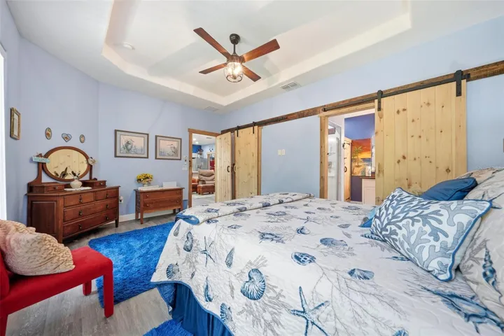 Primary bedroom with custom sliding doors and tray ceilings