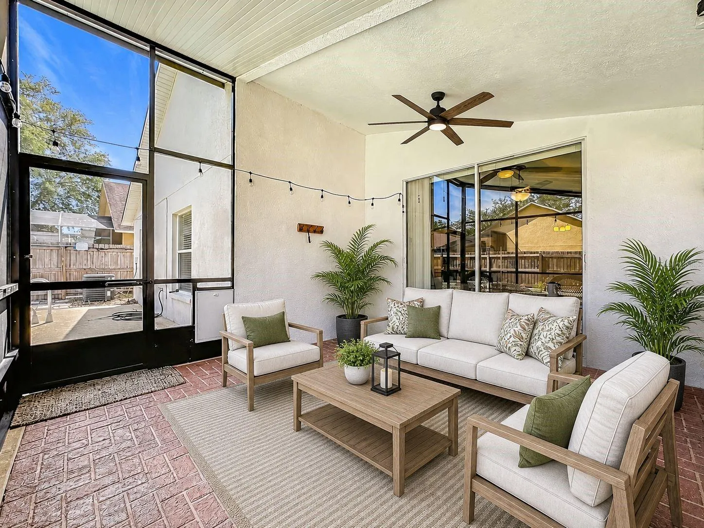 Extended, fully screened-in lanai equipped with an attached exhaust fan—perfect for outdoor dining.