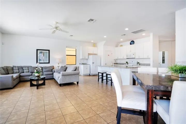 Open living and dining area with tile floors and natural light.