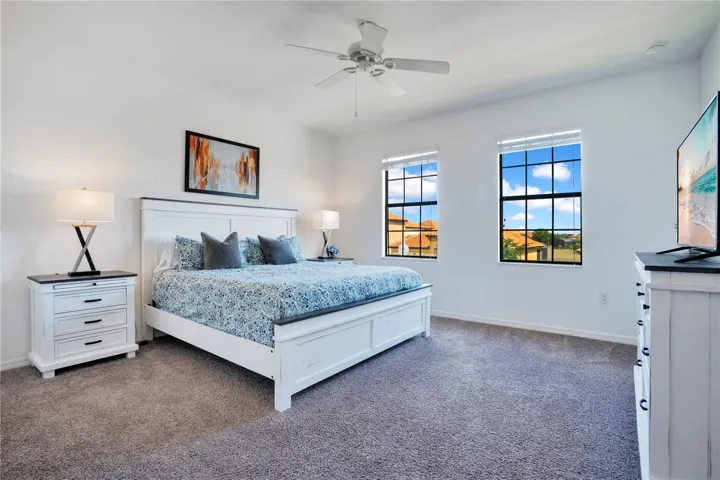 Spacious primary bedroom with large windows and privacy.