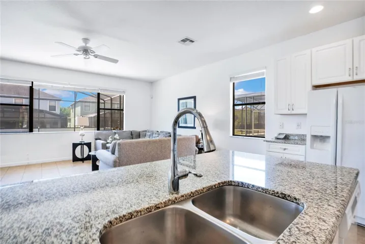 Kitchen sink view with granite counters and open layout.