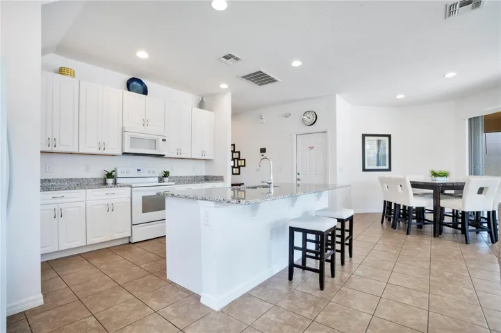 Bright kitchen with white cabinetry and large center island.