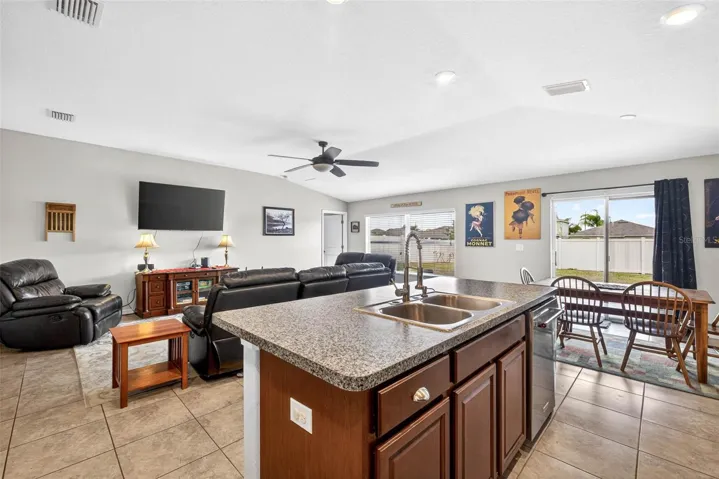 Kitchen/living/dining combination with views of the fully fenced back yard