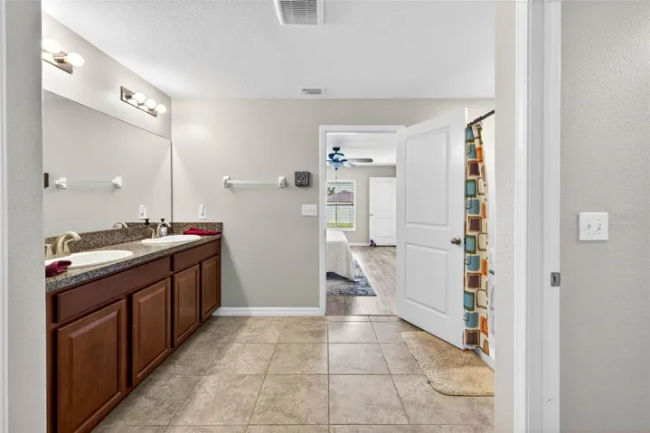 En suite primary bathroom with dual sinks in comfort height vanity.