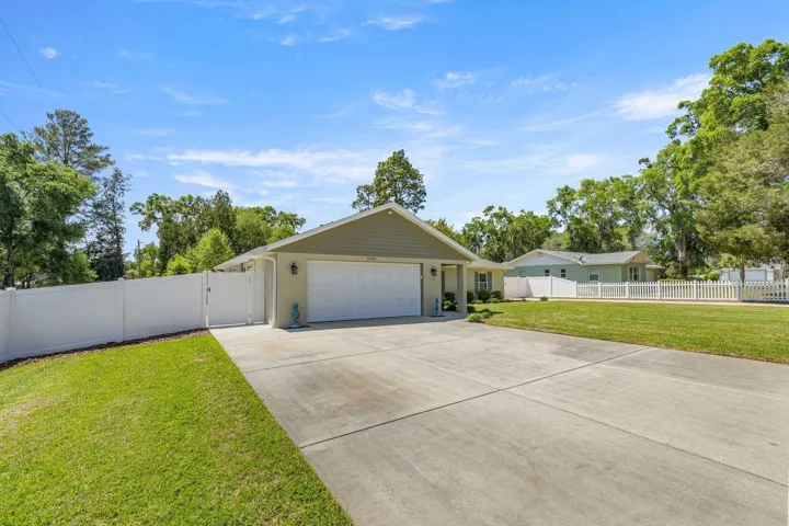 Front with extra wide driveway, 2 car garage and 6 ft fence