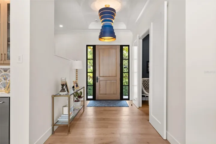 Striking entry foyer highlighted by designer pendant light and sidelights inviting an abundance of natural light