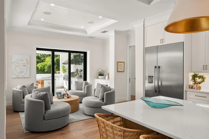 Comfortable seating creates a cozy gathering space, while sliding glass doors open to the outdoor kitchen and entertaining area for effortless indoor-outdoor living