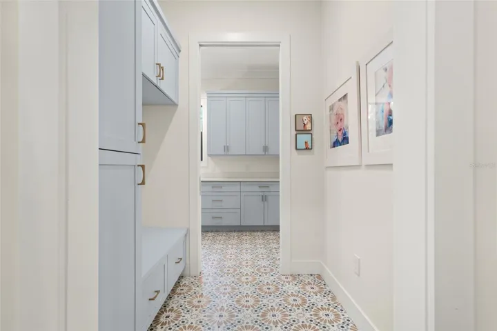 Mudroom with custom cabinetry ideal for built-in organization, and decorative tile flooring