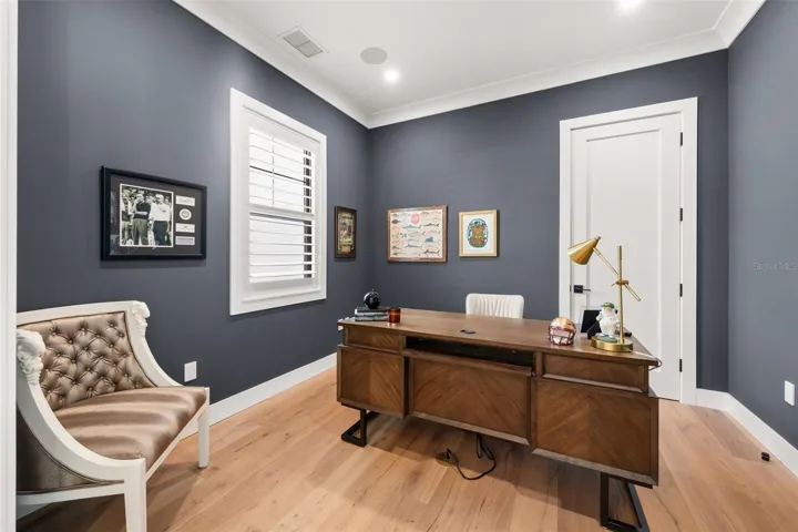 Private office or study, ideal for working from home, featuring elegant crown molding, and sophisticated accent walls