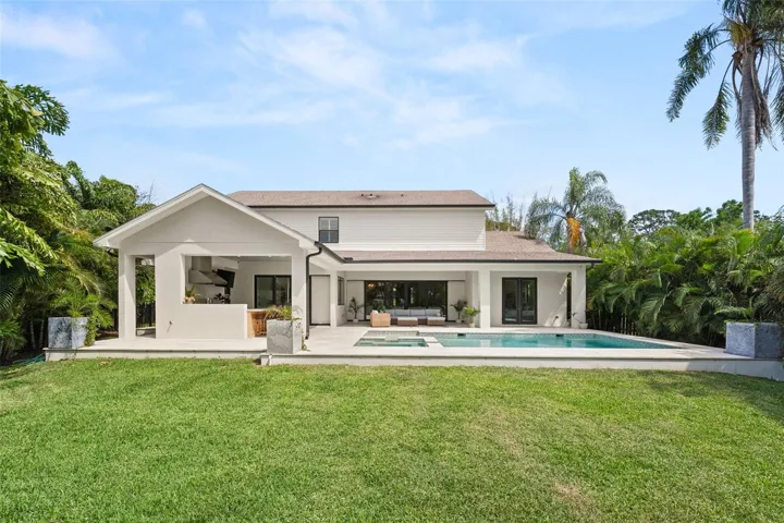 Beautiful backyard elevation surrounded by lush tropical landscaping for ultimate privacy and year-round enjoyment