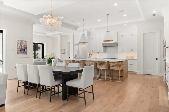 Expansive open-concept living featuring warm hardwood floors and designer lighting