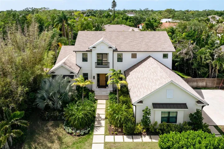 Custom designed residence showcasing timeless architecture, lush tropical landscaping, and exceptional curb appeal