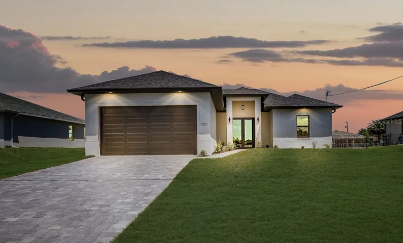 Front of home with a pavered driveway.