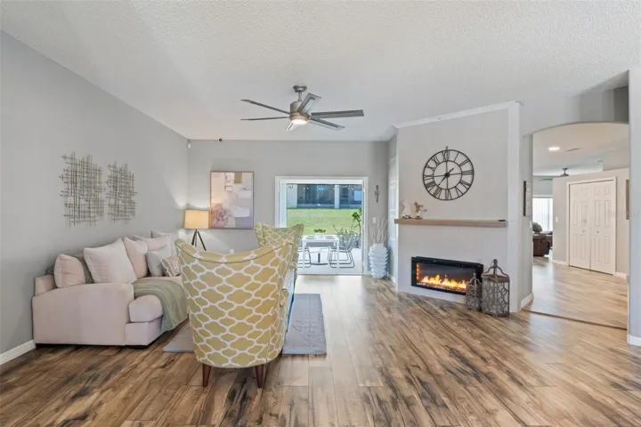 The spacious living room offers a cozy electric fireplace with a mantel and French doors that provide delightful views of the screened-in patio