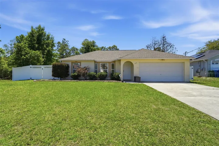 Front exterior of home featuring 2-car garage, bay window, and spacious front yard