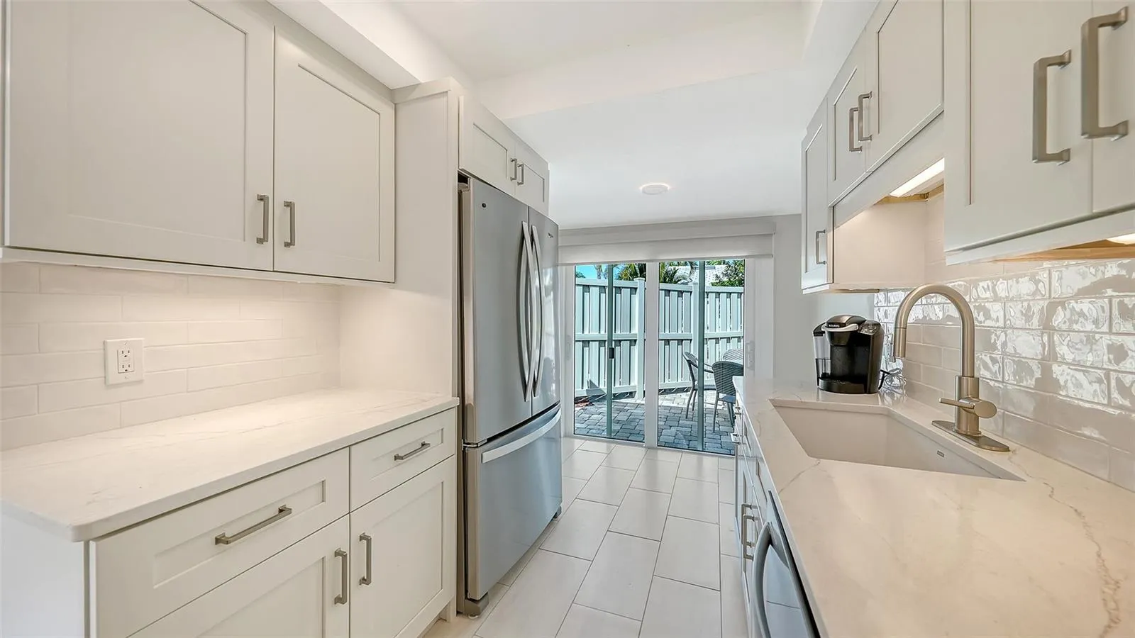 Floor to ceiling sliders open from the kitchen into the patio, for ease of entertaining and grilling.