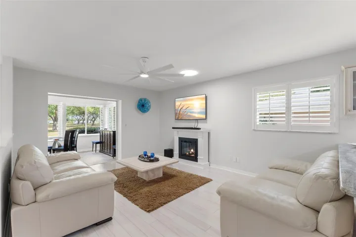 FAMILY TV ROOM LOOKING OUT TO FAIRWAY AND BACKYARD WITH PAVED SITTING AREA