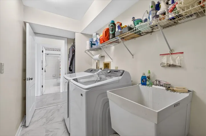 Laundry room with sink W/D and laudry chute from primary closet behind door.