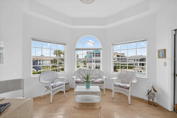Alcove off primary suite with water views and door to screened balcony deck.
