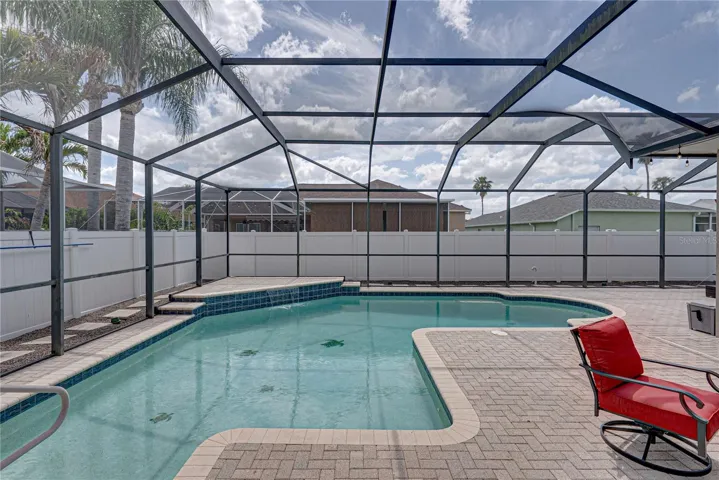 Expansive outdoor living with a large lanai, pool, and lounge area, all set in a low-maintenance backyard designed for effortless Florida living and entertaining.