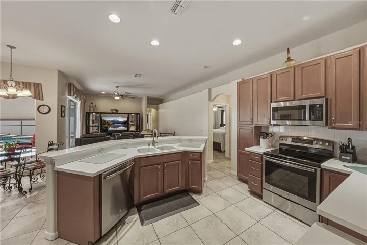 Bright, open-concept kitchen flowing into a cozy breakfast nook and spacious family room, perfect for everyday living and entertaining with direct access to the pool.