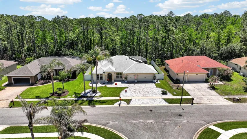 Aerial view of home and woods behind