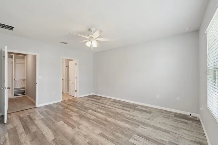 Relaxing primary suite with LVP flooring, huge walk in, custom built closet and spacious bath.