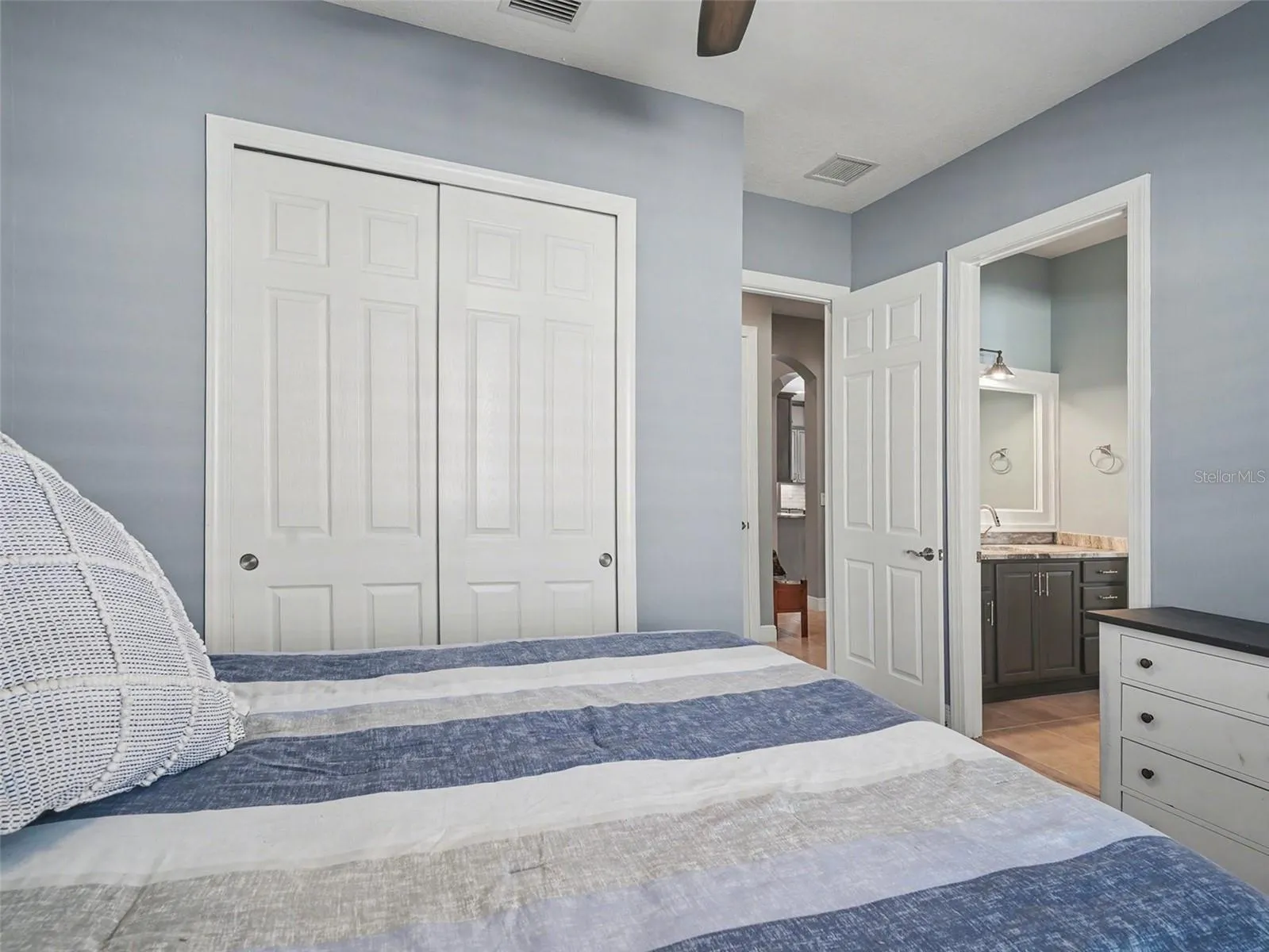Guest bedroom with spacious closet, neutral finishes, and an airy design that feels both functional and inviting.