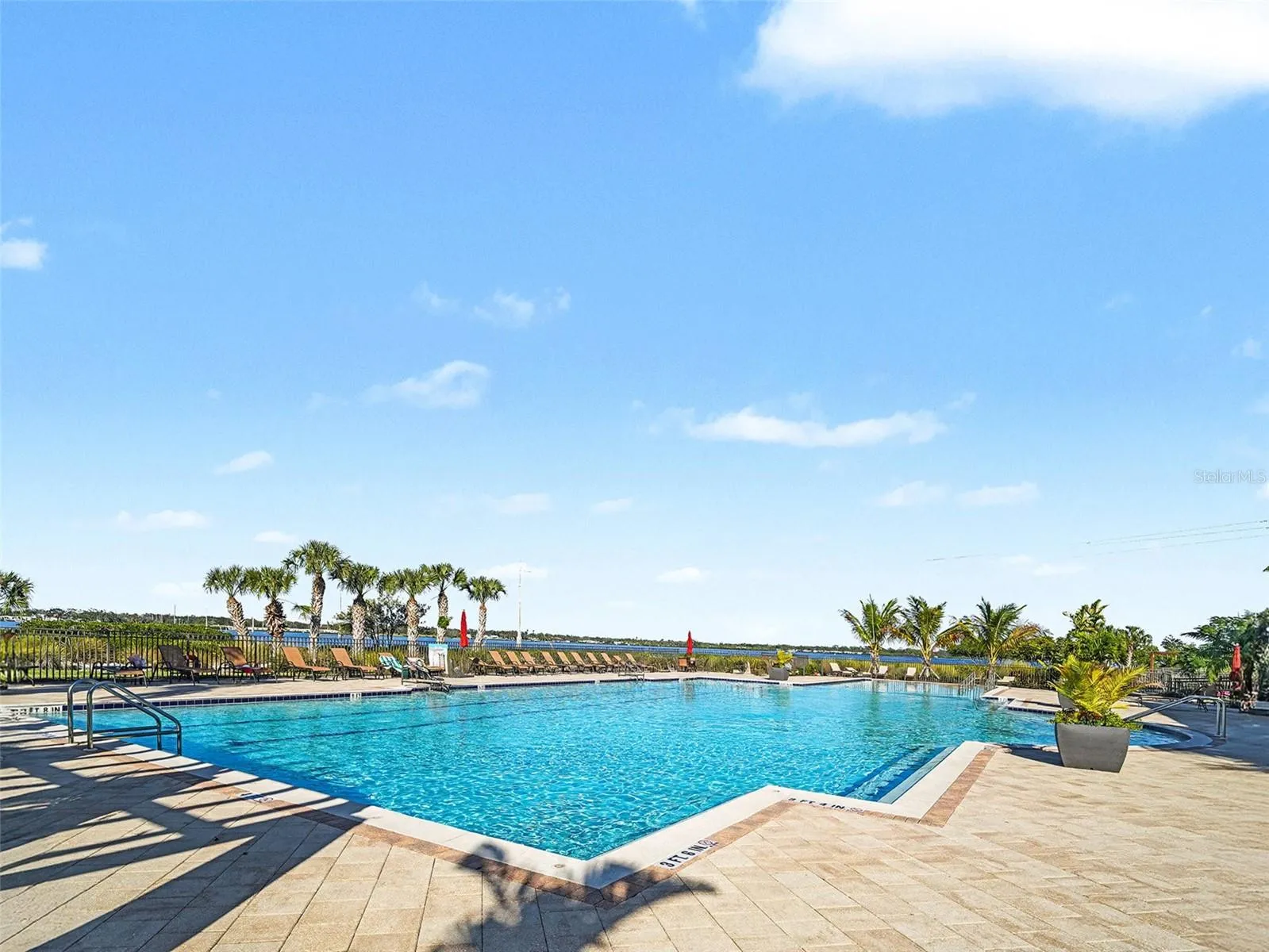 Community pool with expansive water views, creating a resort style amenity for relaxation and recreation.