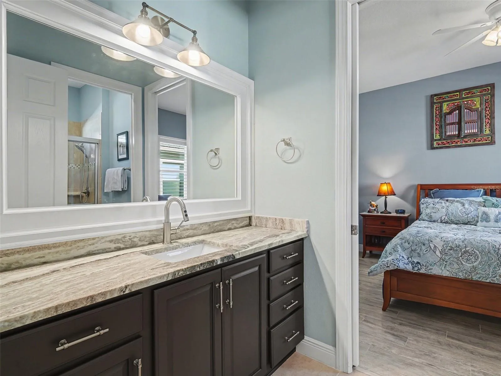 Well designed guest bathroom vanity with ample counter space, stylish finishes, and convenient access to the adjacent bedroom.