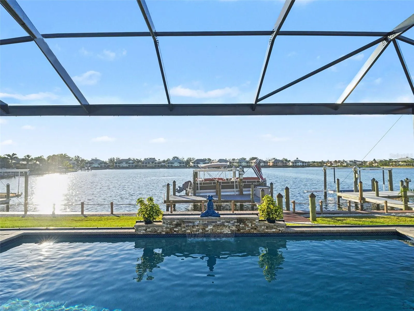 Screened waterfront lanai with panoramic water views, ideal for outdoor dining, entertaining, and enjoying the coastal lifestyle.