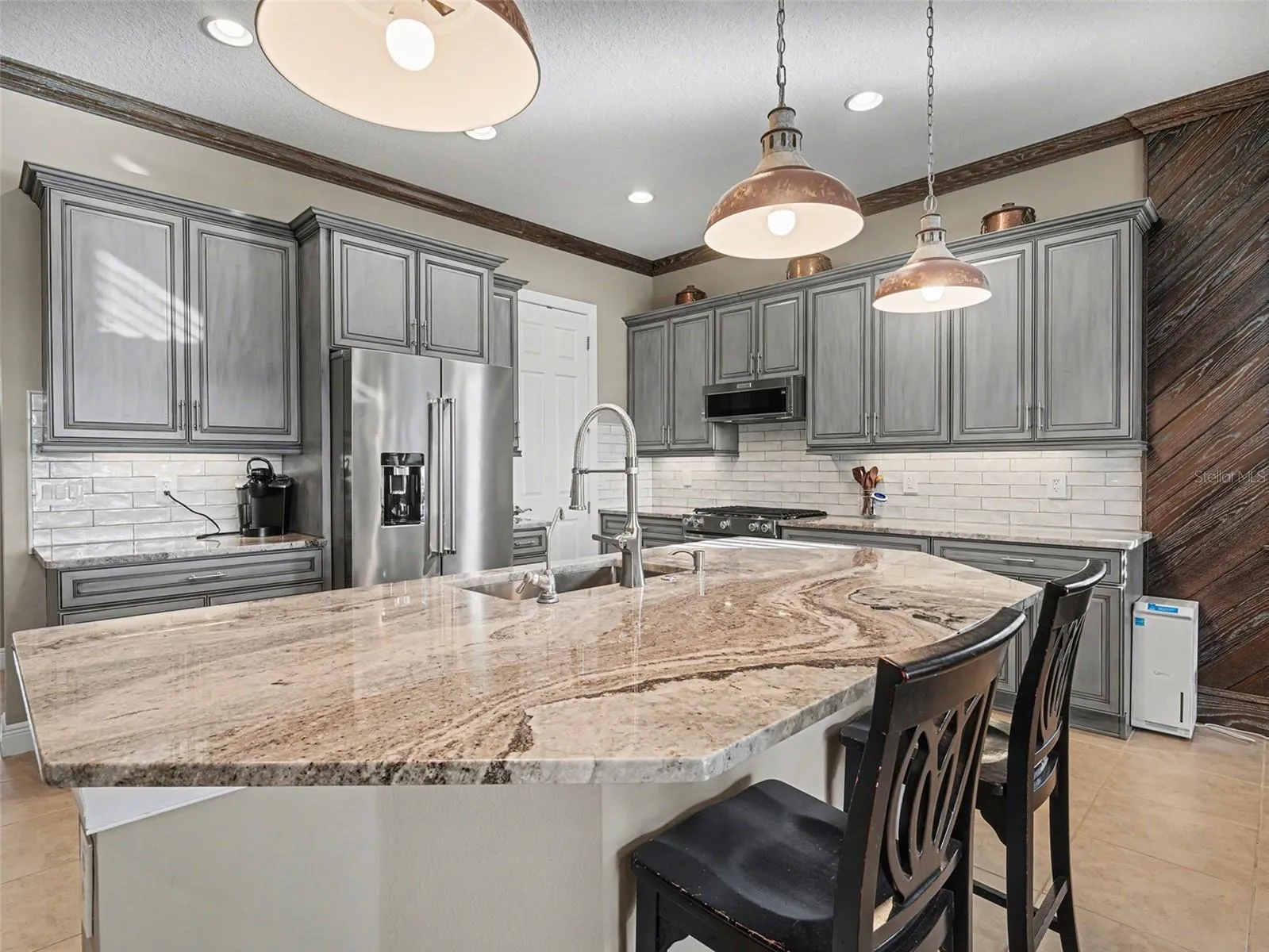 Elegant kitchen with expansive island seating, designer lighting, and seamless flow into the main living areas.